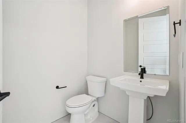 a bathroom with a sink toilet and a mirror