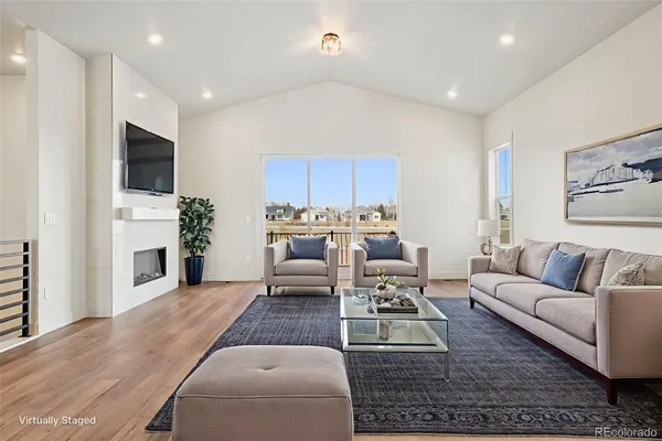 a living room with furniture a fireplace and a flat screen tv