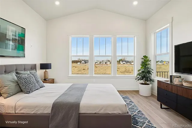 a bedroom with a large bed and a potted plant
