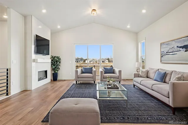 a living room with furniture a fireplace and a flat screen tv
