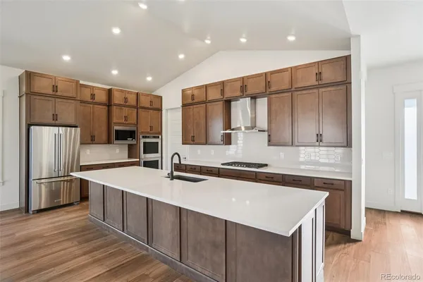 a kitchen with stainless steel appliances a sink stove and refrigerator