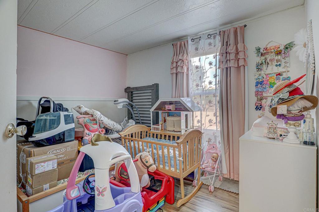 2515 Sweetwater Road, Unit SPC #23 Spring Valley, CA 91977 - Photo 14 of 21 a bedroom with furniture and a baby crib