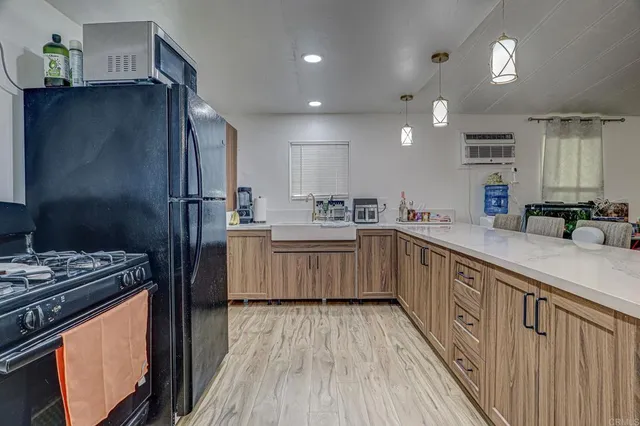 a kitchen with stainless steel appliances a refrigerator a sink dishwasher a stove and white countertops with wooden floor