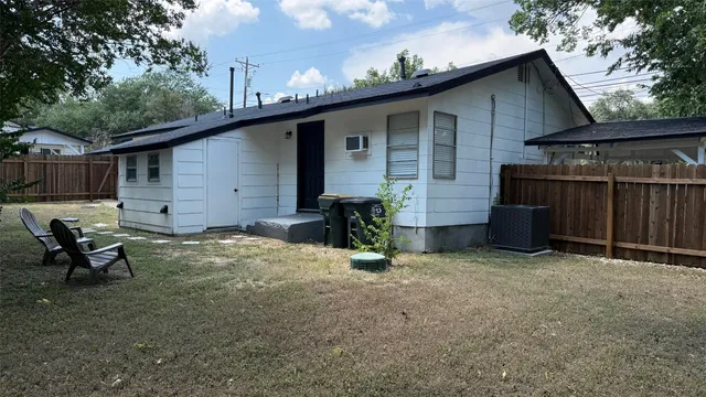 a backyard of a house with table and chairs