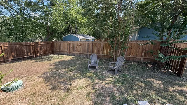 a view of a backyard with a small cabin and a chair