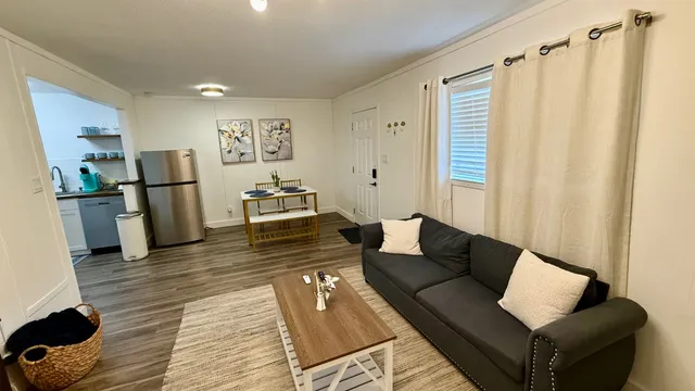 a living room with furniture and a wooden floor