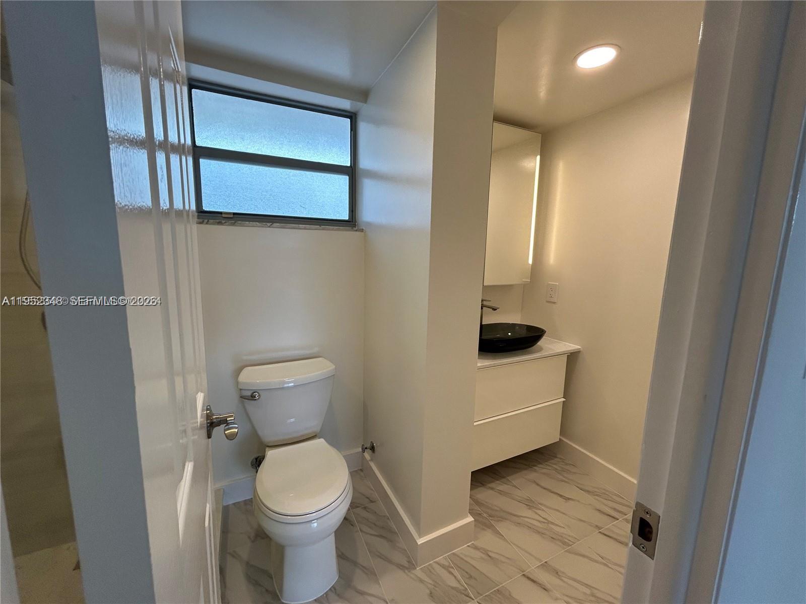 3550 Northeast 169th Street, Unit 304 North Miami Beach, FL 33160 - Photo 11 of 25 a bathroom with a toilet and a sink