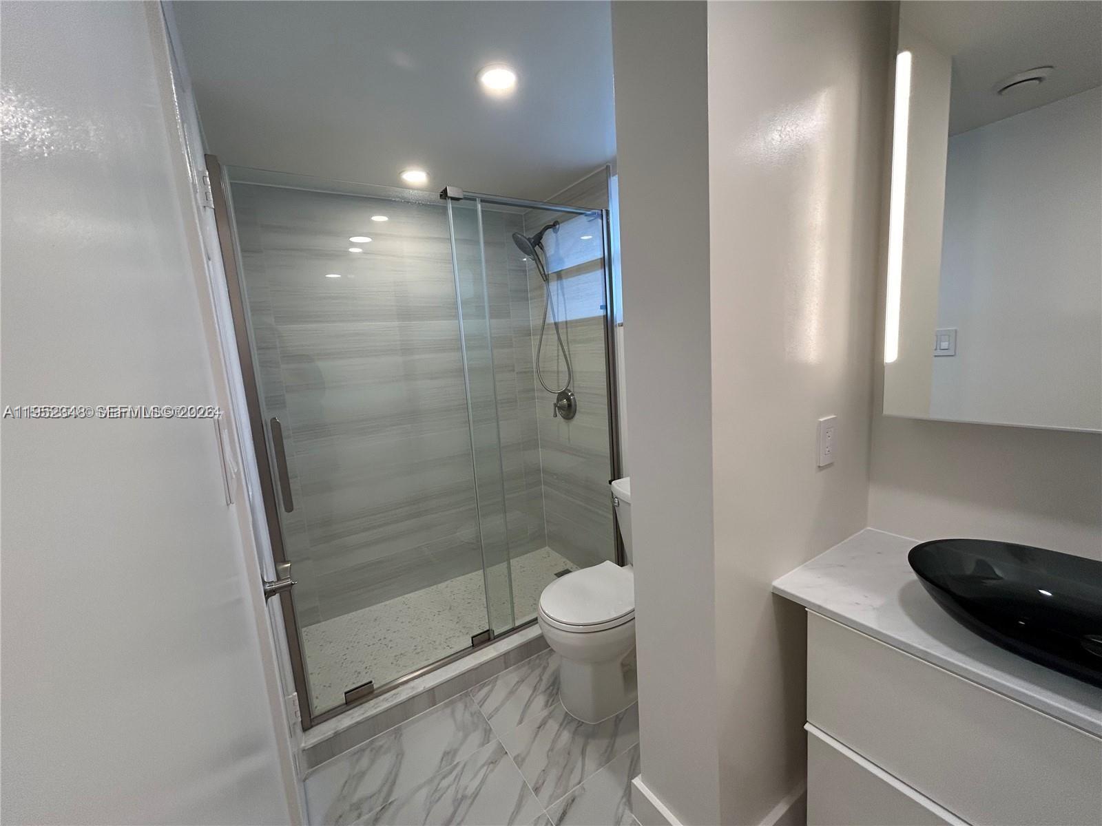 3550 Northeast 169th Street, Unit 304 North Miami Beach, FL 33160 - Photo 12 of 25 a bathroom with a shower and a toilet