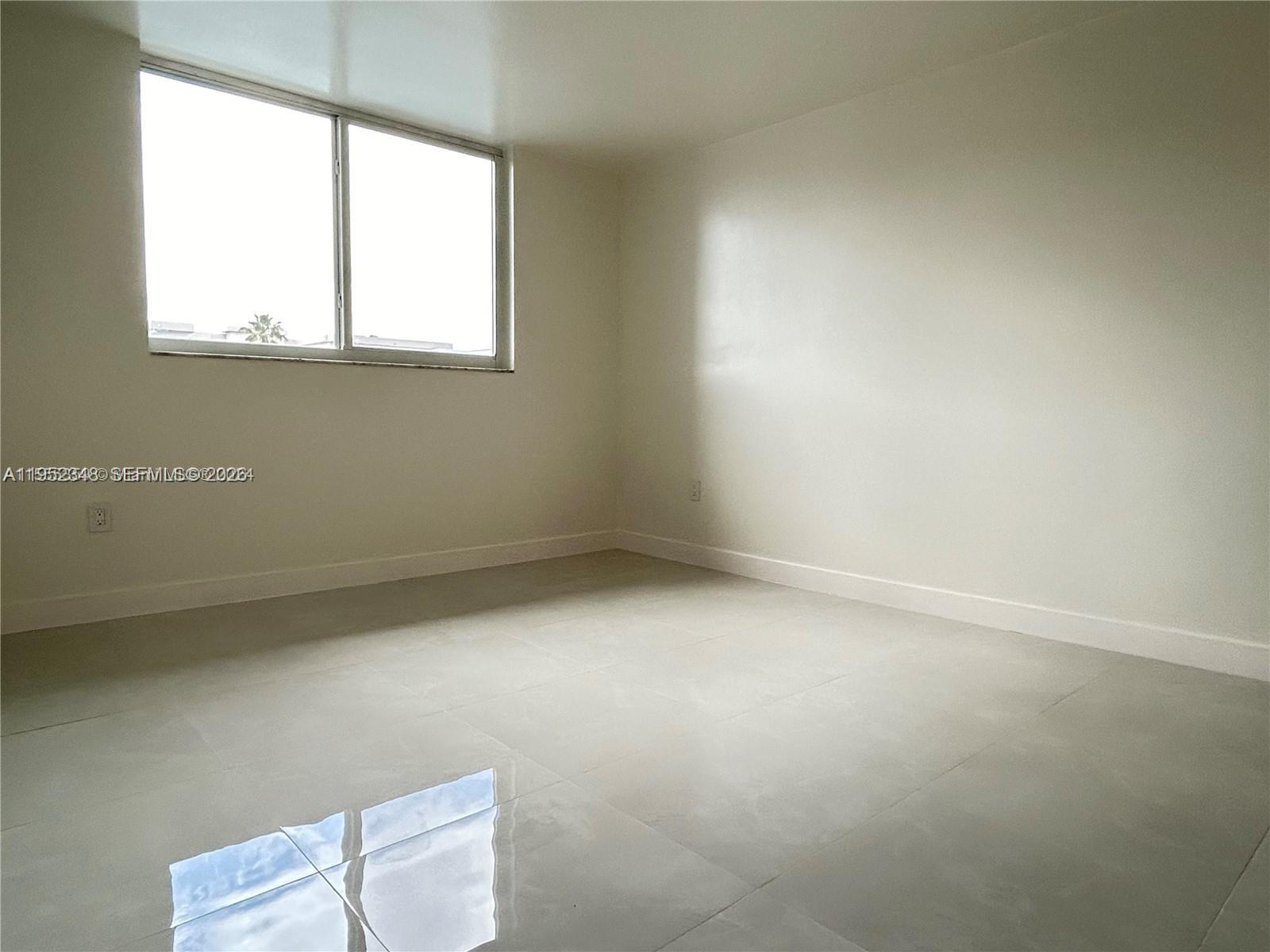 3550 Northeast 169th Street, Unit 304 North Miami Beach, FL 33160 - Photo 21 of 25 an empty room with a window