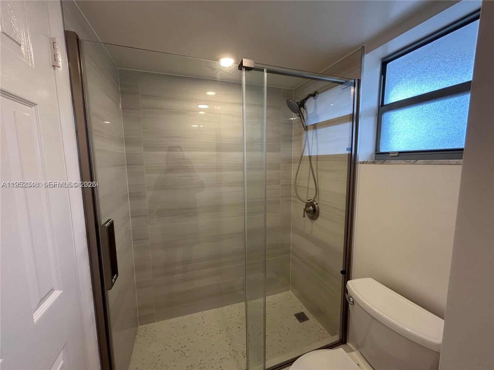 3550 Northeast 169th Street, Unit 304 North Miami Beach, FL 33160 - Photo 5 of 25 a bathroom with a shower and toilet