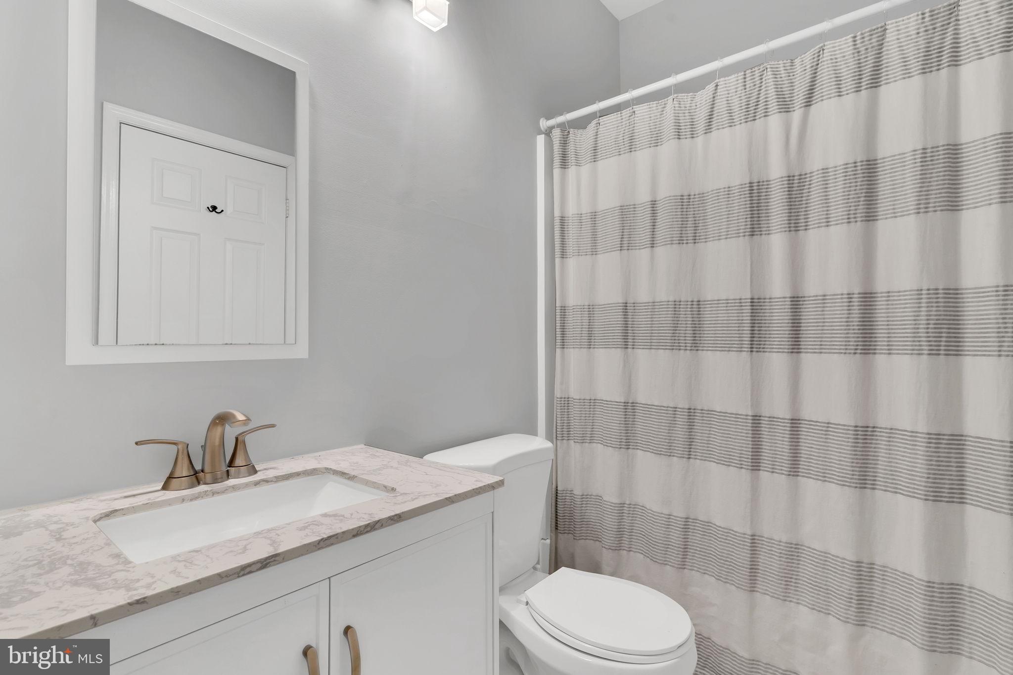 604 Moonglow Road, Unit 104 Odenton, MD 21113 - Photo 16 of 19 a bathroom with a granite countertop bathtub sink vanity mirror and toilet