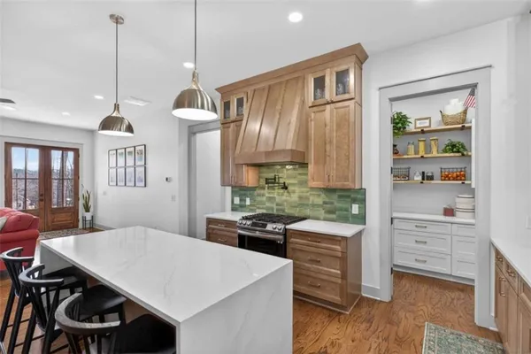 a kitchen with stainless steel appliances a dining table chairs and wooden floor