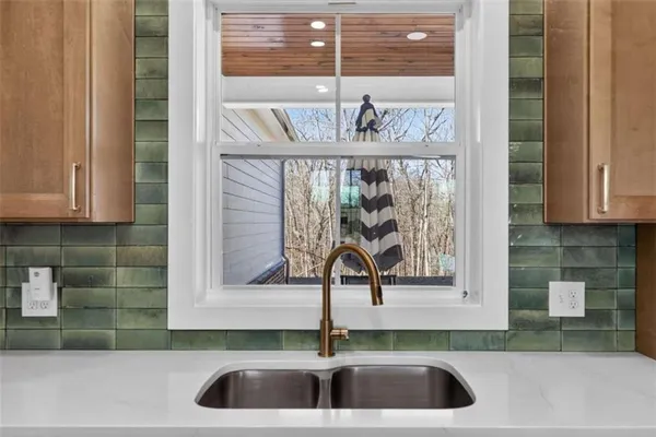 a room with kitchen island stainless steel appliances a dining table chairs and wooden floor