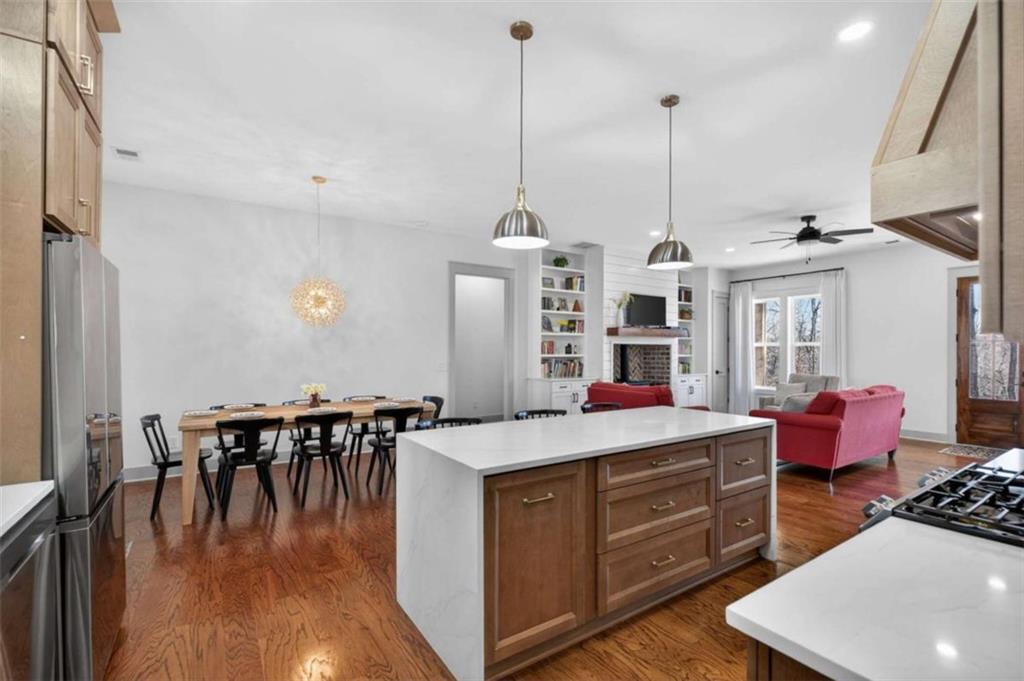 433 Old Roanoke Road Bowdon, GA 30108 - Photo 15 of 52 a room with kitchen island stainless steel appliances a dining table chairs and wooden floor