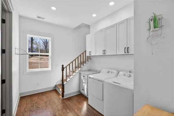 a view of a hallway with bathroom and wooden floor
