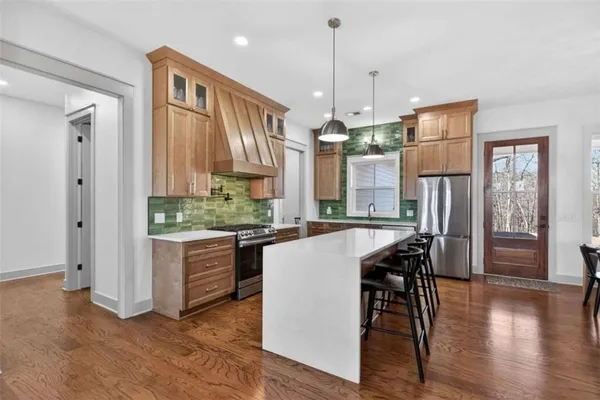 a kitchen that has a lot of cabinets a sink a stove and wooden floor