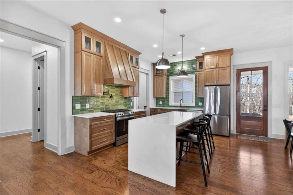 433 Old Roanoke Road Bowdon, GA 30108 - Photo 10 of 52 a kitchen with stainless steel appliances granite countertop a refrigerator a sink dishwasher a stove and a dining table with wooden floor