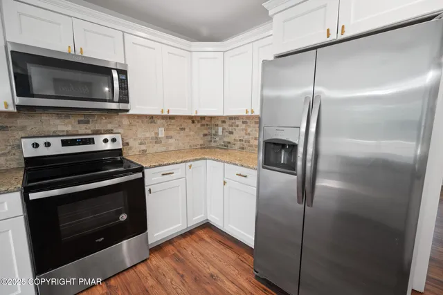 a kitchen with a refrigerator stove and microwave