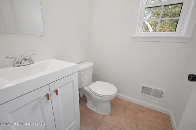 a bathroom with a sink toilet and a window