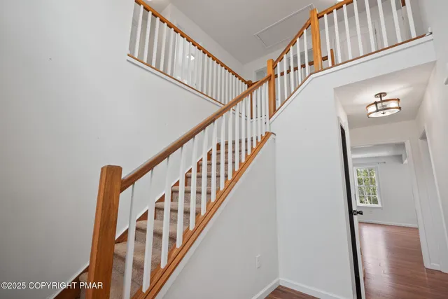 a view of staircase with wooden floor and a chandelier