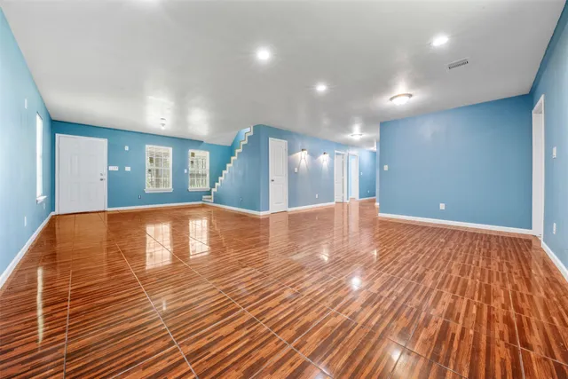 a view of empty room with wooden floor
