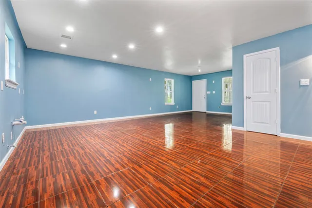 a view of an empty room with wooden floor