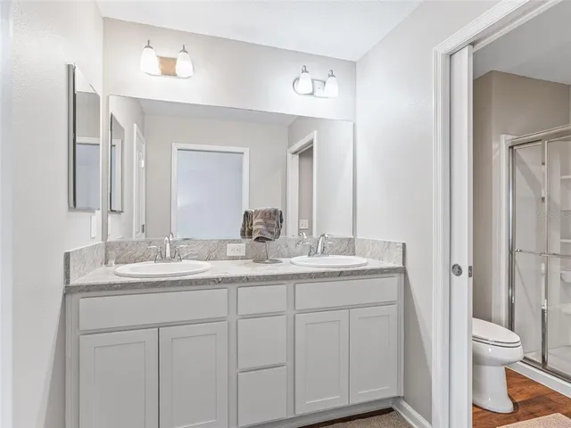 a bathroom with a granite countertop toilet a sink and a mirror