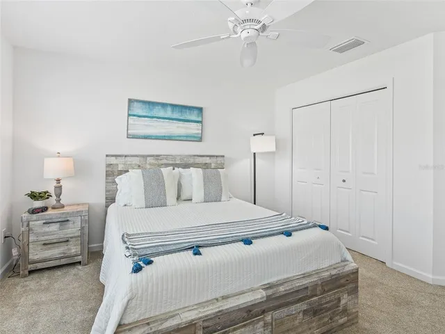 a bedroom with a bed and a lamp on the dresser