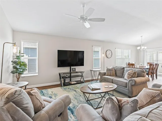 a living room with furniture a flat screen tv and a large window