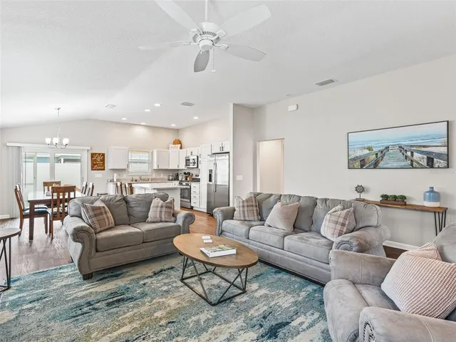a living room with furniture kitchen view and a table