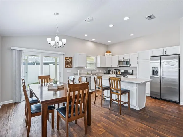 a view of kitchen with refrigerator dining table and chairs