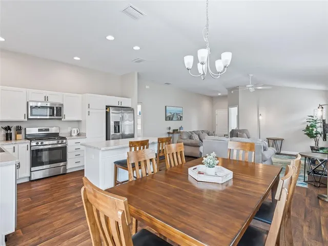 a view of a dining room with furniture a chandelier and wooden floor