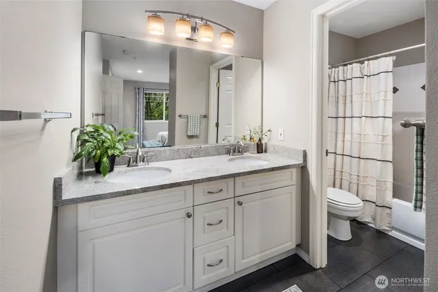 a bathroom with a double vanity sink toilet and shower