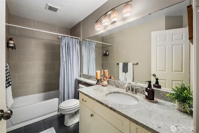 a bathroom with a granite countertop sink toilet and shower