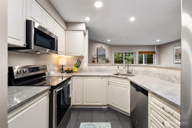 a kitchen with a sink stainless steel appliances and white cabinets
