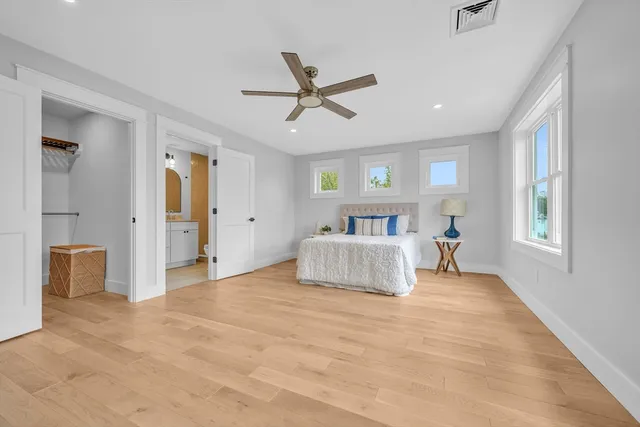 a bedroom with a large bed and a chandelier