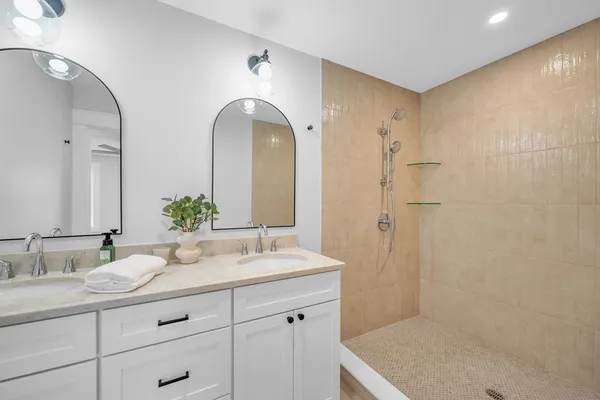 a bathroom with a granite countertop sink a mirror and a shower