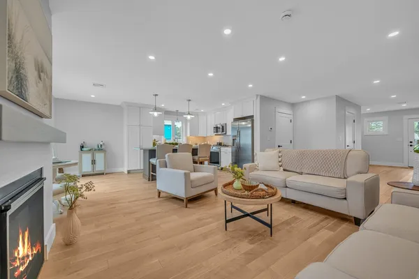 a living room with furniture white wooden floor and a fireplace