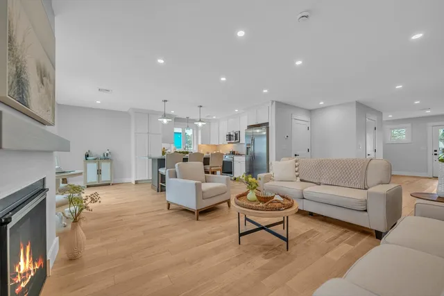 a living room with furniture white wooden floor and a fireplace
