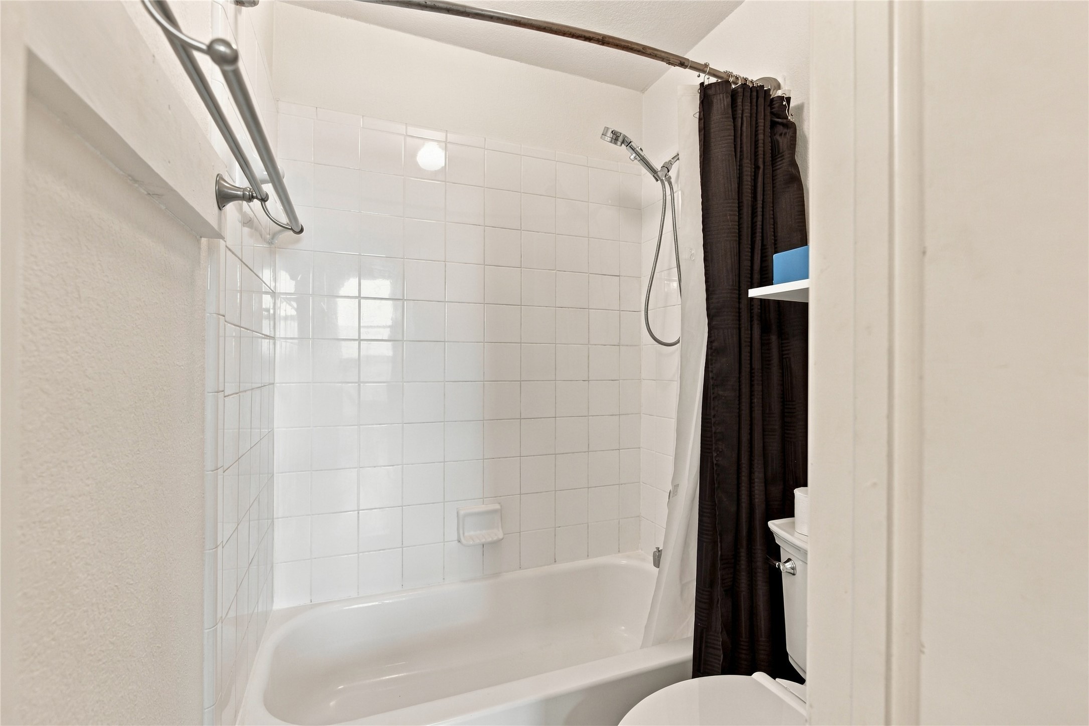 910 Point Run Drive Pflugerville, TX 78660 - Photo 26 of 39 Crisp white wall tiles frame the integrated soaking tub in this bathroom.
