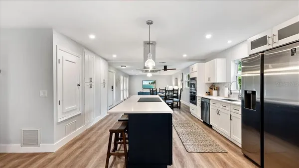 a large kitchen with sink and stainless steel appliances
