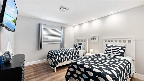 a bedroom with two beds and a flat screen tv