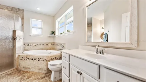 a bathroom with a tub sink and mirror