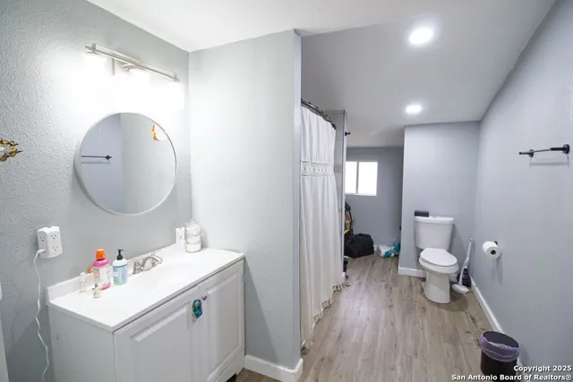 a bathroom with a sink mirror and toilet