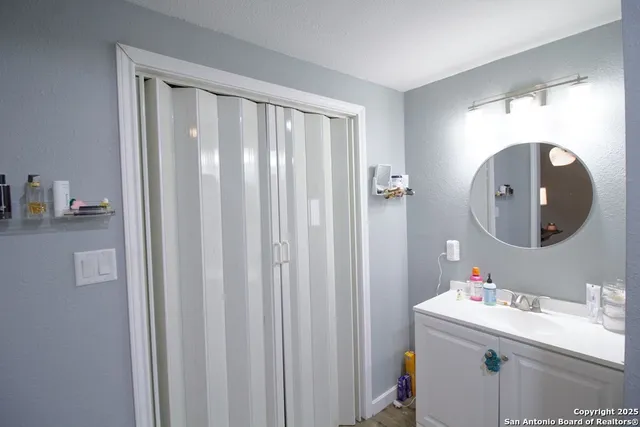 a bathroom with a sink vanity and a mirror