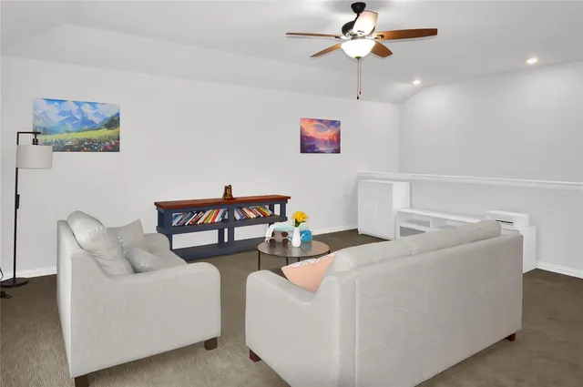 a living room with furniture and a ceiling fan