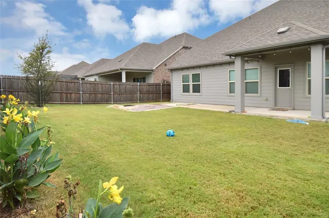 a view of a house with backyard and sitting area