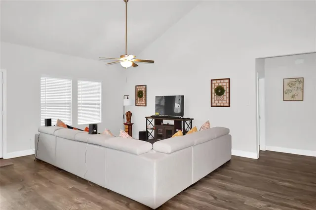 a living room with furniture a chandelier and a flat screen tv