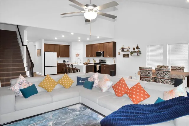a living room with furniture kitchen view and a chandelier