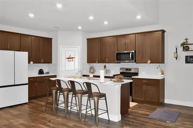 a kitchen with stainless steel appliances a stove top oven a refrigerator a sink and a microwave